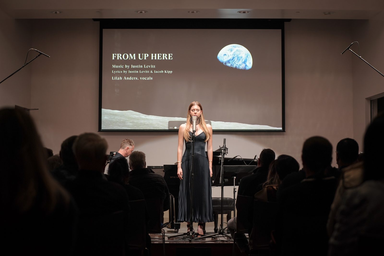 Lilah Anders sings From Up Here with Justin Levitt at the piano as the Earthrise image fills the screen